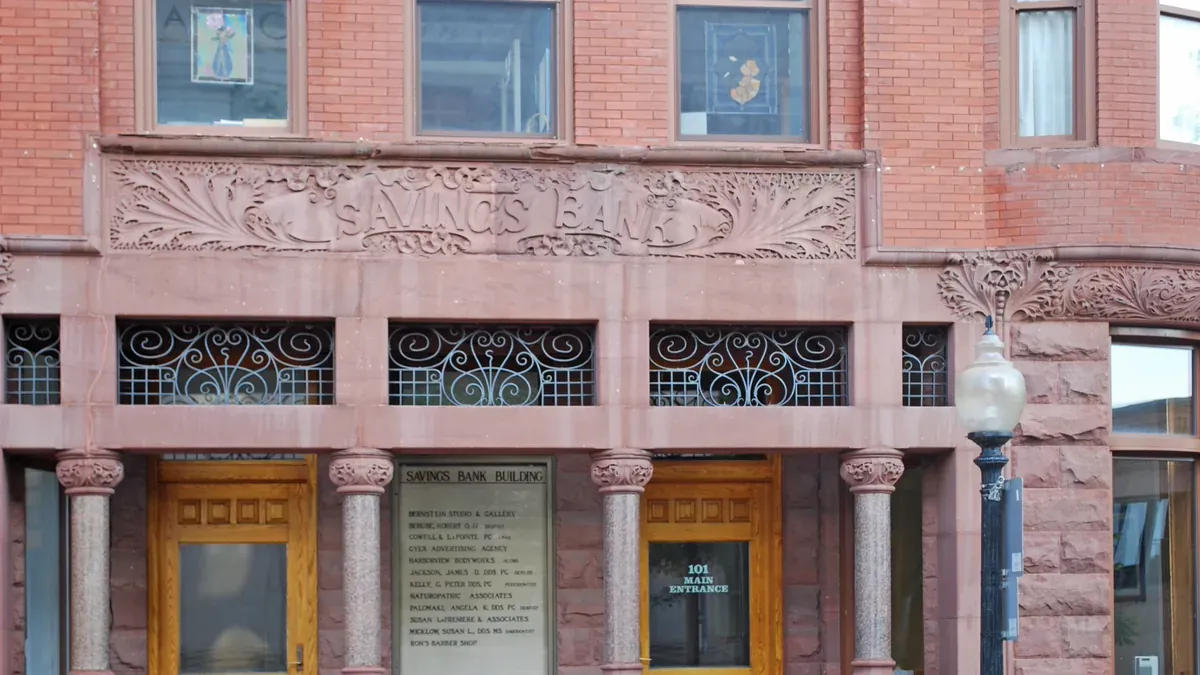 The stone-carved Savings Bank entrance of a historic red-brick building in Marquette, Michigan.