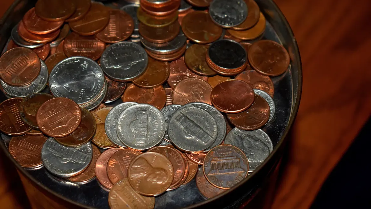 Close-up of a glass jar filled with U.S. pennies, nickels and other coins saved as a cash reserve